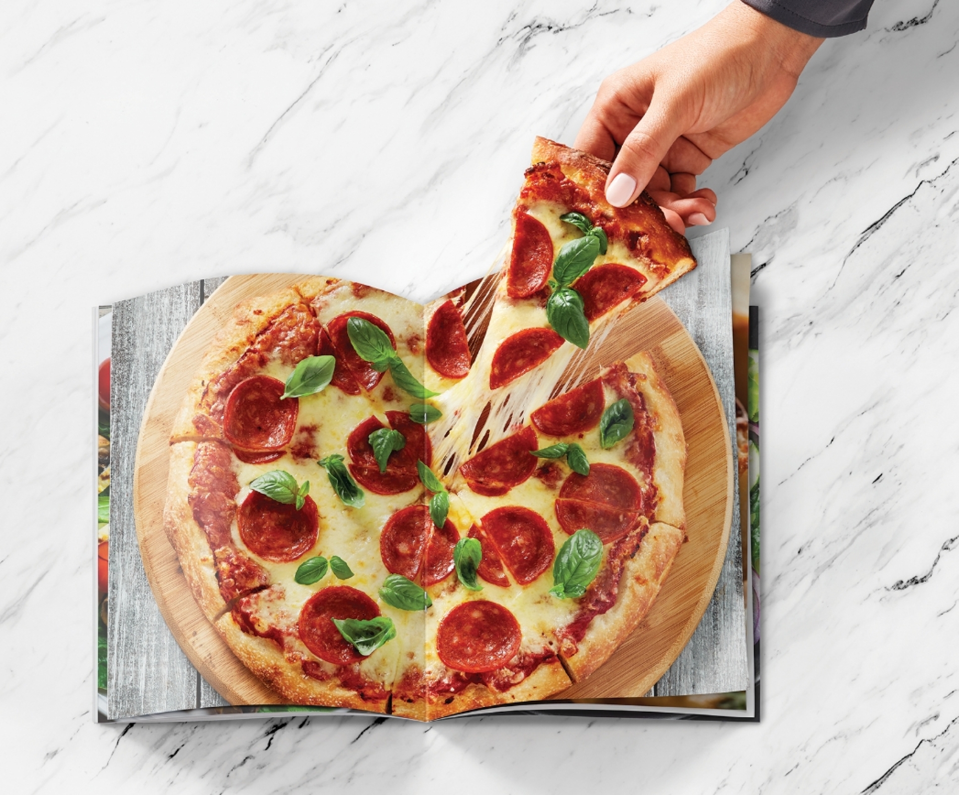 Ampersand creative print ad showing a slice of real pizza being pulled out of a magazine picture of a pizza
